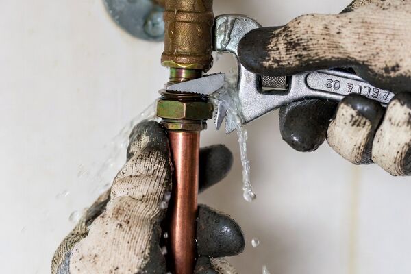 Emergency plumber repairing a burst water pipe